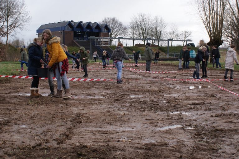 Schoolkinderen zaaien bloemen in voor meer bijen en vlinders